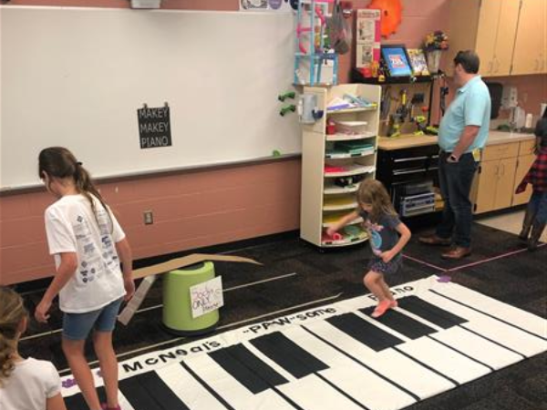 two children play piano on the floor